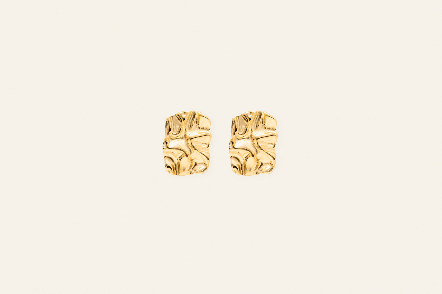 Stora fyrkantiga örhängen i guld med en smältande design taget framifrån mot en ljus bakgrund.