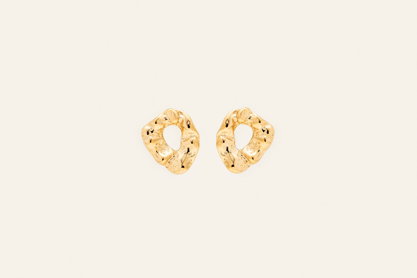 Chunky gold earrings with a molten gold design shaped as oval rings.