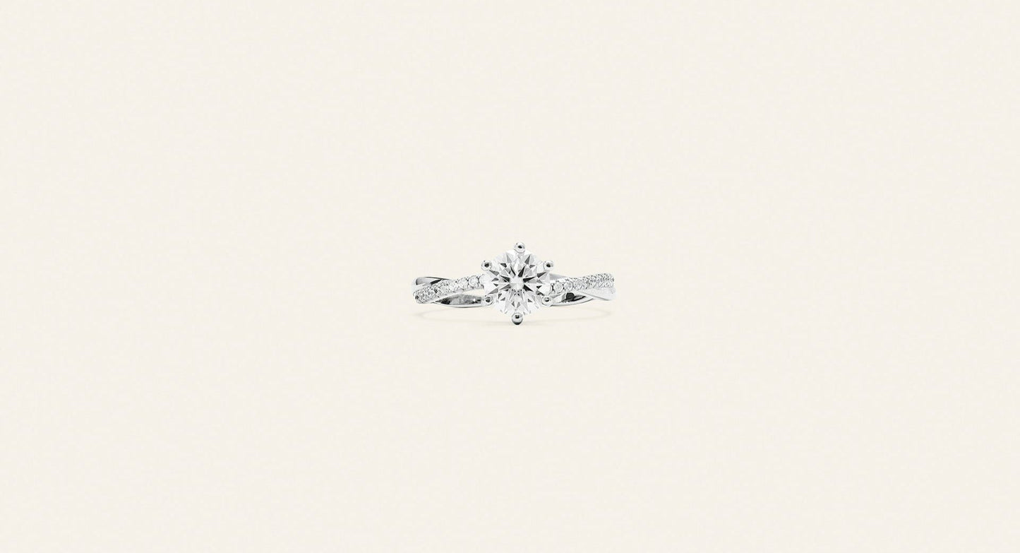 Elegant solitärring i silver med små silverkristaller runt om den stora kristallen som är placerad i mitten. Bakgrunden är ljusbeige. 