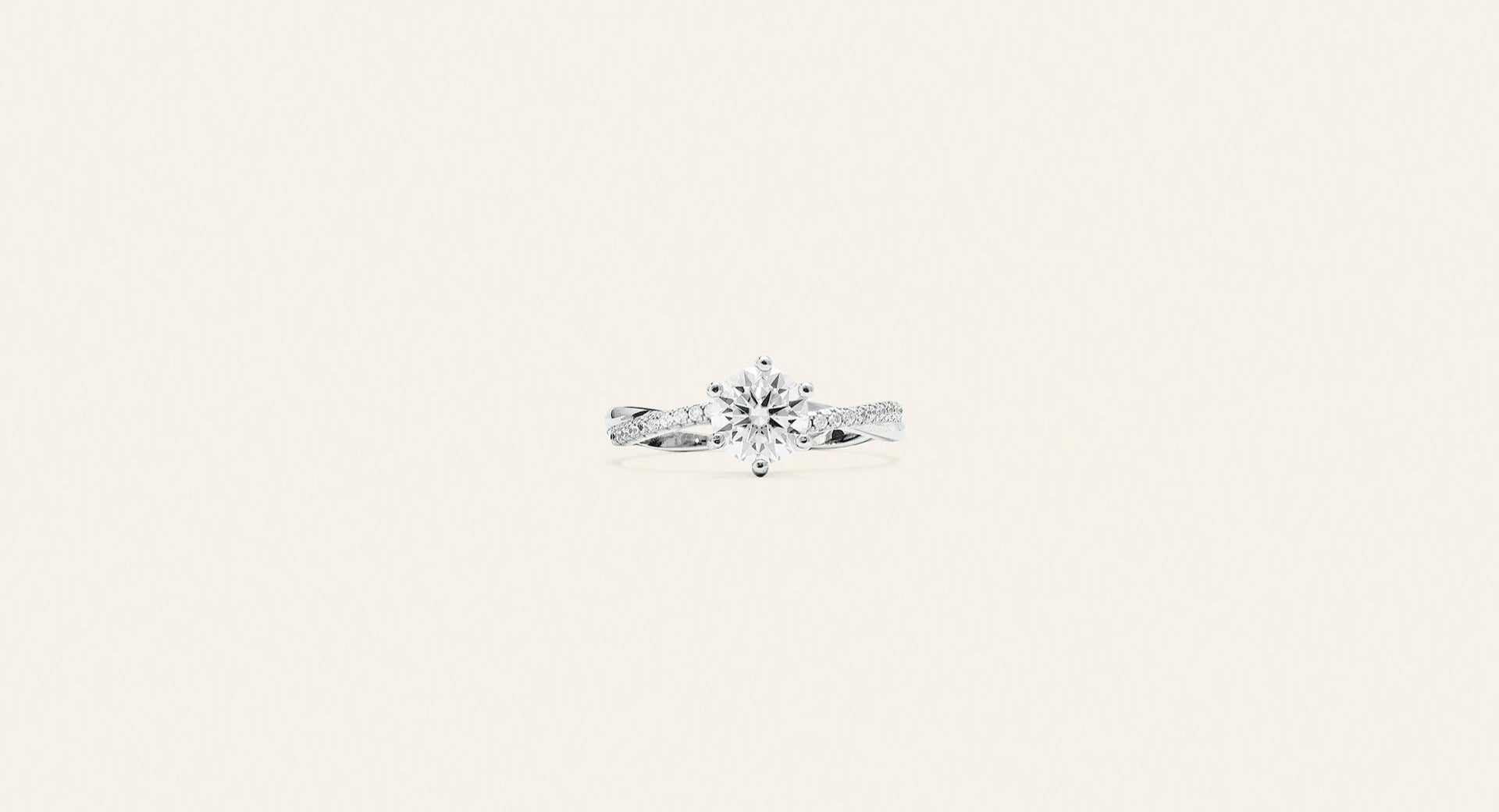Elegant solitärring i silver med små silverkristaller runt om den stora kristallen som är placerad i mitten. Bakgrunden är ljusbeige. 